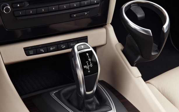 BMW's electronic shifter - found in most new BMWs - is easy to use once you get used to it. Note the third swing-out cup holder for either the passenger or driver. It's right in the way of the passenger's knee. It's beautifully-engineered, but not terribly sturdy. 