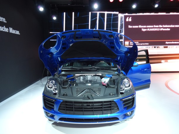 Here is the 2015 Porsche Macan, nearly naked with its standard 3.0L V6 engine showing. Note how the hood wraps around the sides, rather than just the top, of the car. 